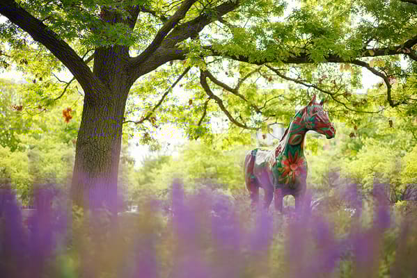 Colorful horse statue in a flower garden