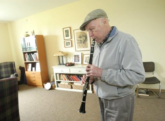Resident playing the clarinet in a cozy lounge