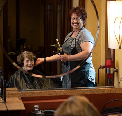 Resident receiving a hair styling in the salon