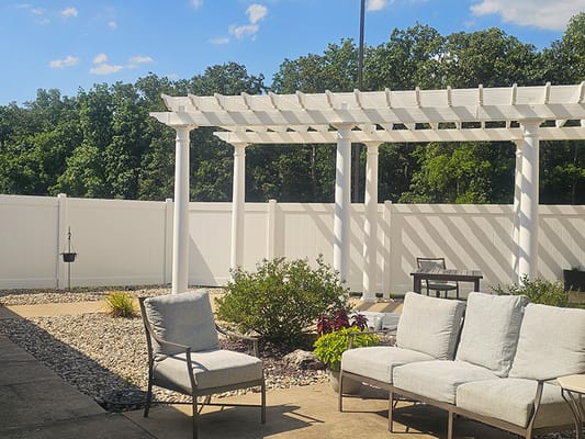 Outdoor seating area with a pergola and landscaping