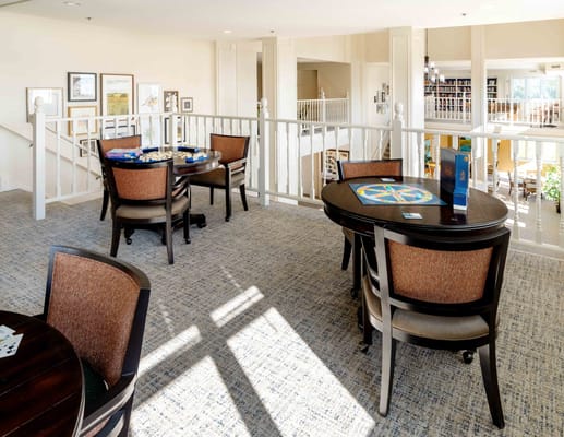 Bright common area with tables and games for residents