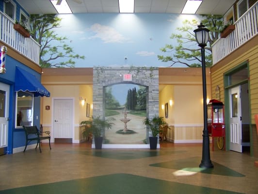 Interior view of a brightly lit common area with mural
