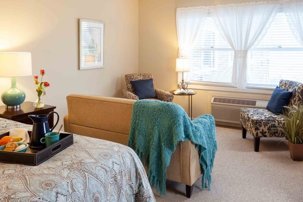 Cozy interior of a resident room with a bed and seating area