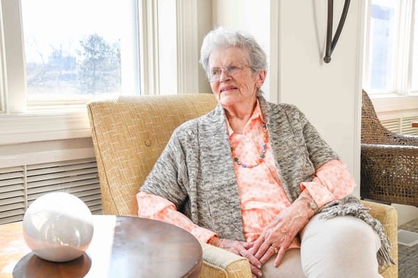 Senior resident relaxing in a bright, sunny living area