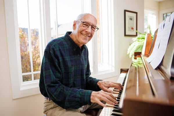Resident playing the piano in a bright room