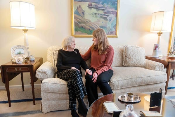 Resident and staff member chatting in a cozy living room