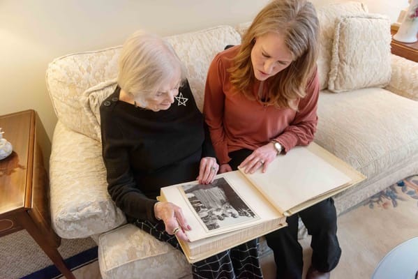 Resident and staff member sharing a photo album