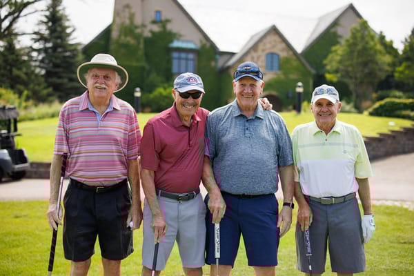 Four senior men enjoying a game of golf outside