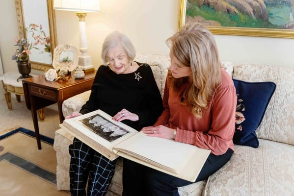 Resident and staff member looking at a photo album together