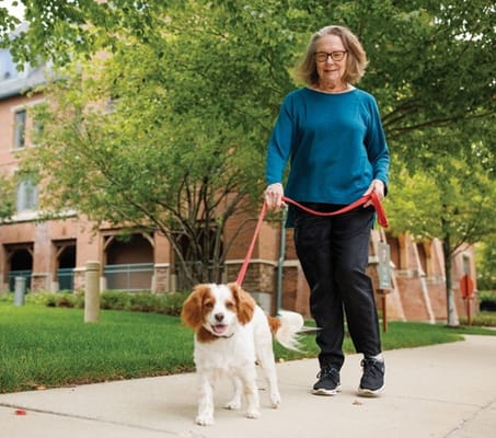 A resident walking a dog near the building