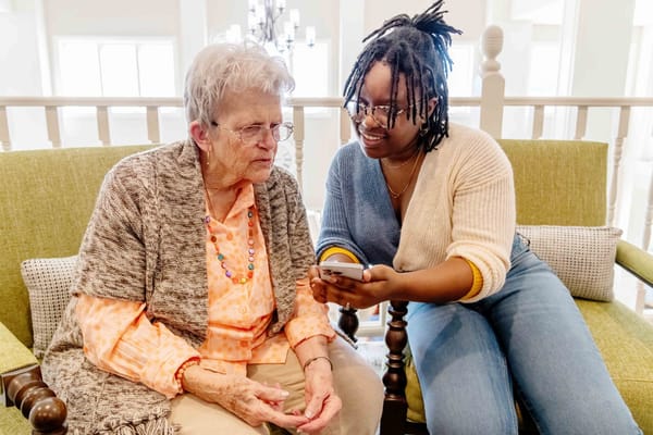 A resident and staff member sharing a moment in a cozy lounge