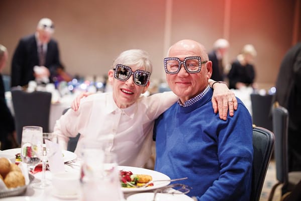 Residents enjoying a meal in celebration with large eyeglasses