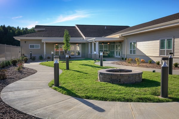 Exterior view of a senior living facility with a garden path
