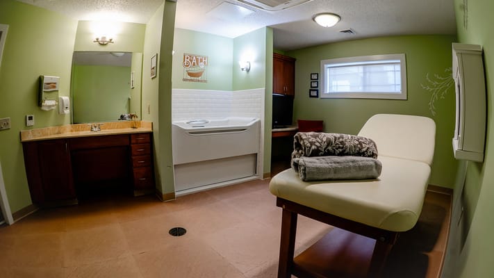 Therapy room with a massage table and bathing equipment
