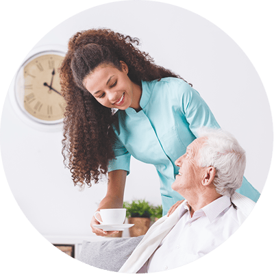 Caregiver serving coffee to a resident in a cozy room