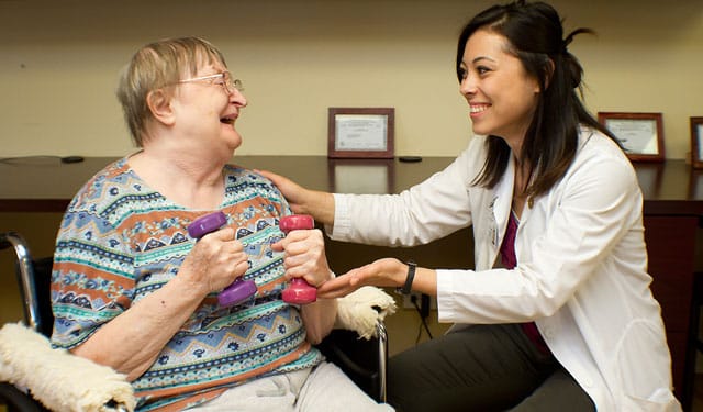 Healthcare worker interacting with a resident during therapy