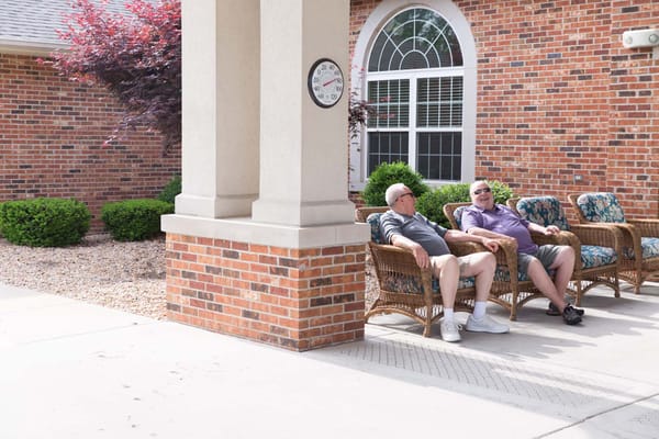 Two residents relaxing on outdoor seating