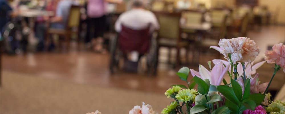 Dining area with residents socializing in the background