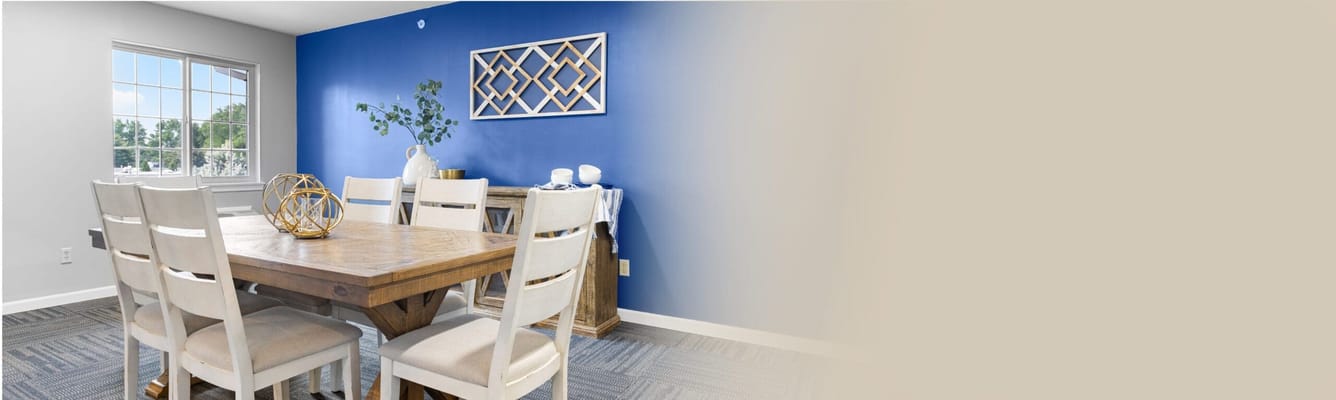 Bright dining room with a wooden table and blue wall