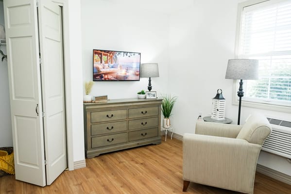 Bright interior of a resident's room with a TV and furniture