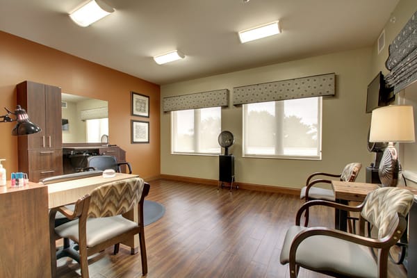 A bright interior room with wooden flooring and furnishings