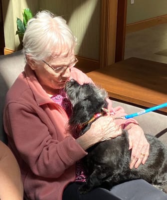 A resident enjoying time with a dog indoors