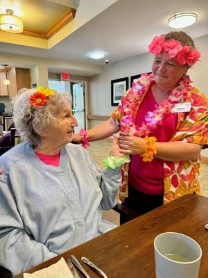 Residents celebrating with floral leis in a common area