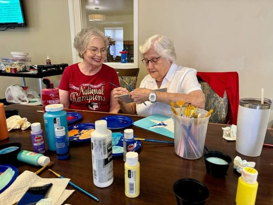 Two residents engaged in a painting activity.