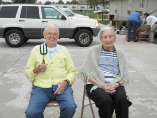 Two residents enjoying time outdoors with gardening tools