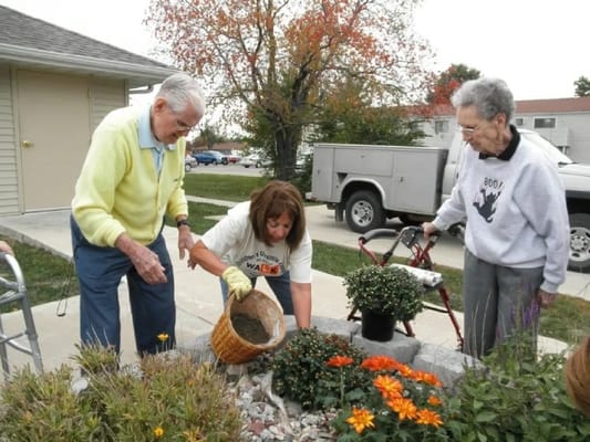Residents gardening with staff assistance