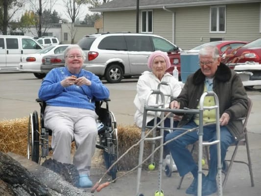 Residents enjoying a fire outside with their caregivers