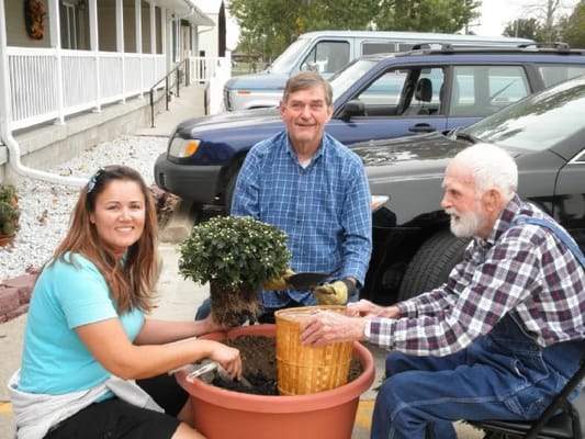 Residents and staff gardening together outside.