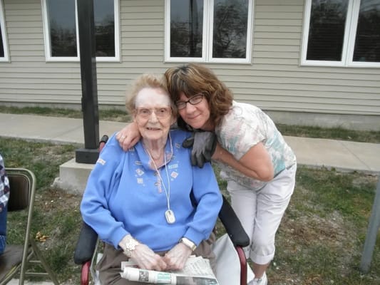 An elderly resident with a staff member outdoors