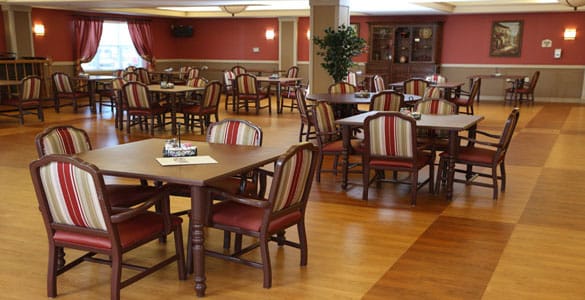 Dining area with tables and chairs in a senior living facility