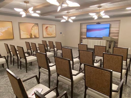 Interior view of a meeting room with chairs and a screen