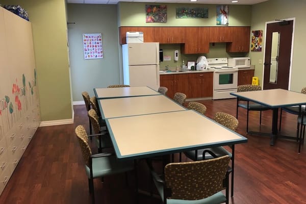 Interior view of a common area with tables and a kitchenette
