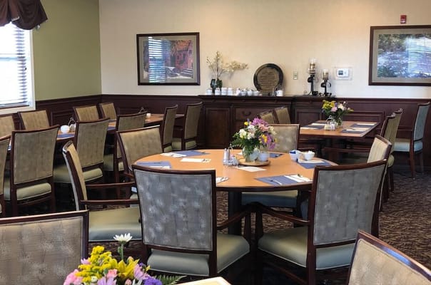 Dining room set up for a meal service with flowers