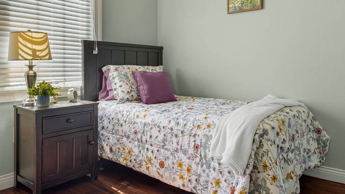 Cozy resident room with floral bedding and lamp