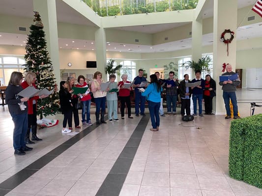 Residents participating in a holiday choir performance in the lobby