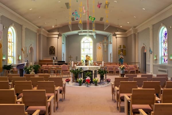 Interior view of a serene chapel with wooden chairs