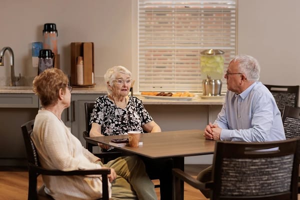 Residents engaged in conversation at a table.