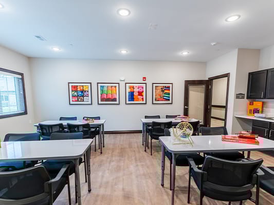 Bright activity room with tables and artwork on the walls
