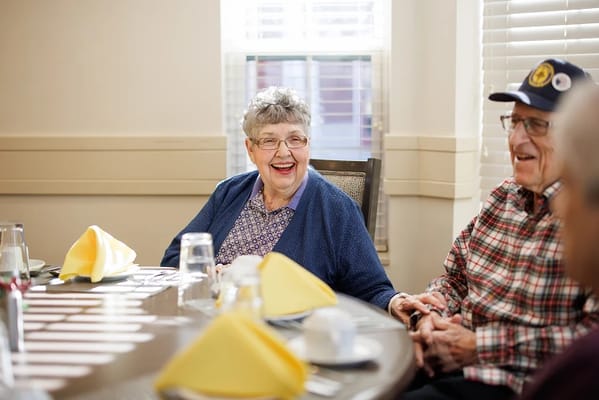Residents enjoying conversation at a dining table