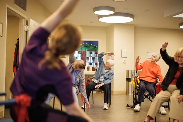Residents participating in a seated exercise class