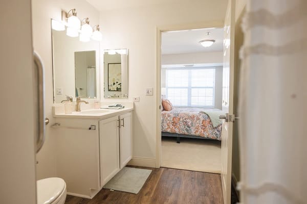 A bright, well-furnished resident bathroom and bedroom.