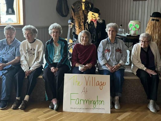 Residents sitting together with a sign for the facility