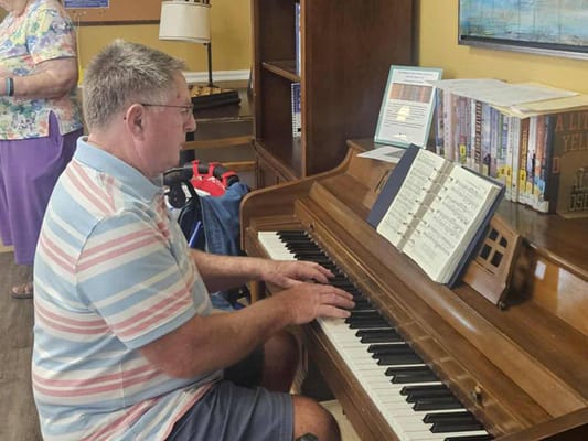 A resident playing piano in a cozy indoor setting