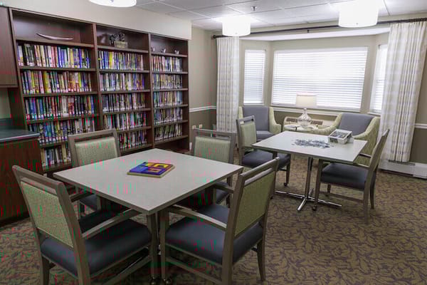Bright common area with bookshelves and puzzle tables