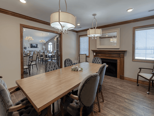 Dining area with a large wooden table and modern lighting