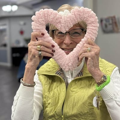 A resident making a heart shape with hands